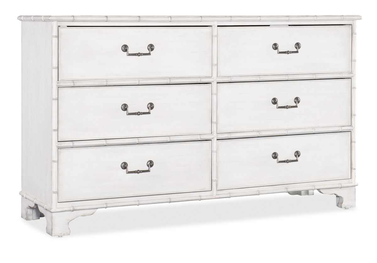 a white dresser with metal handles