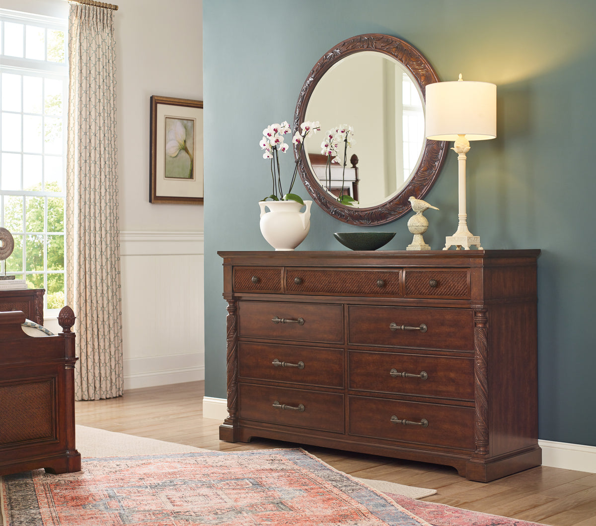 a dresser with a mirror and a lamp