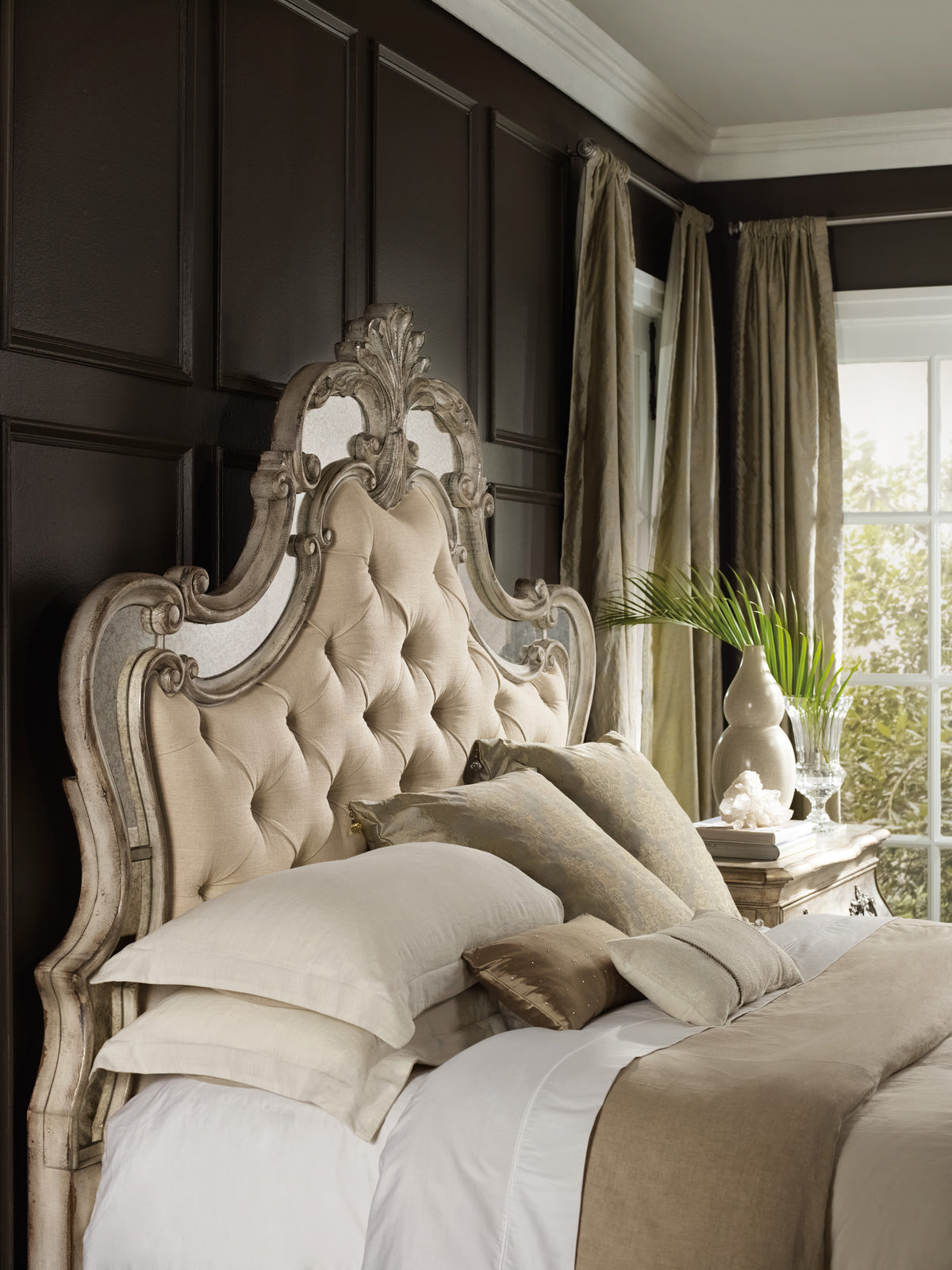 a bed with pillows and a plant in front of a window