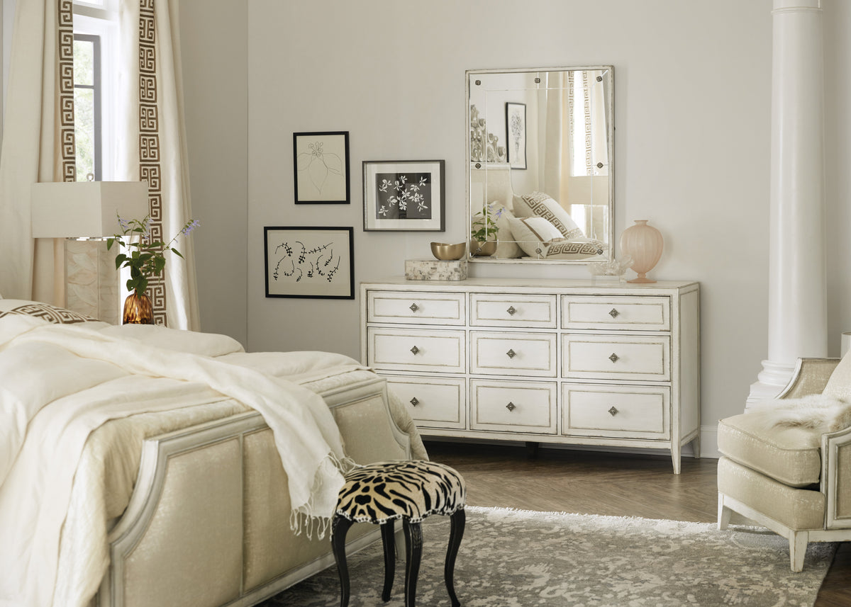 a bedroom with a dresser and a mirror
