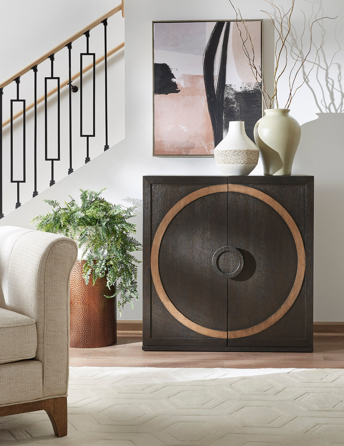 a cabinet with a vase on top and a plant in front of it