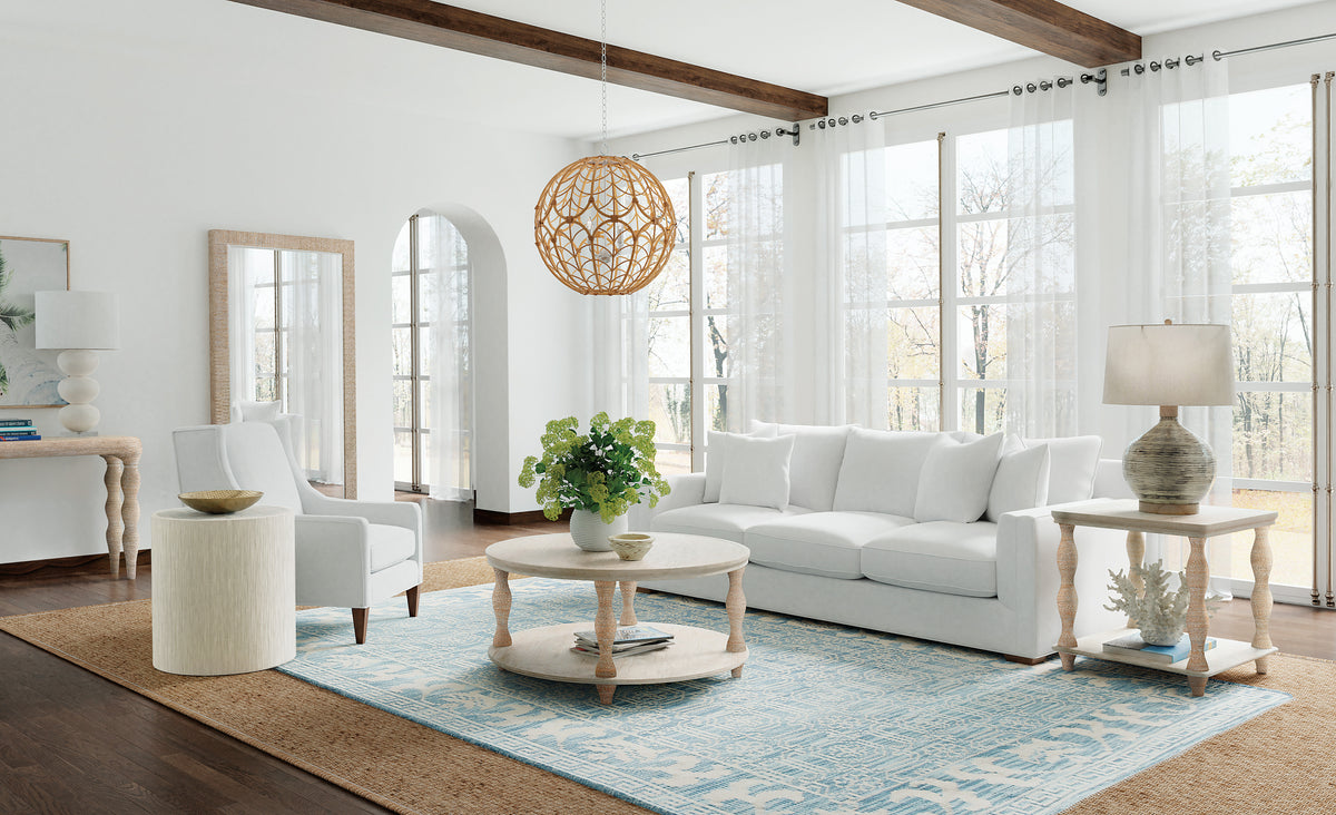 a living room with white furniture and a round coffee table