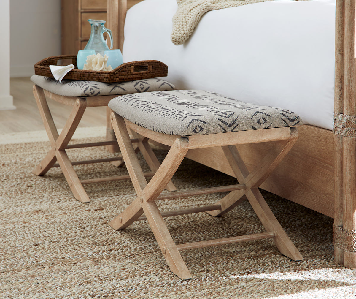 a stool next to a bed