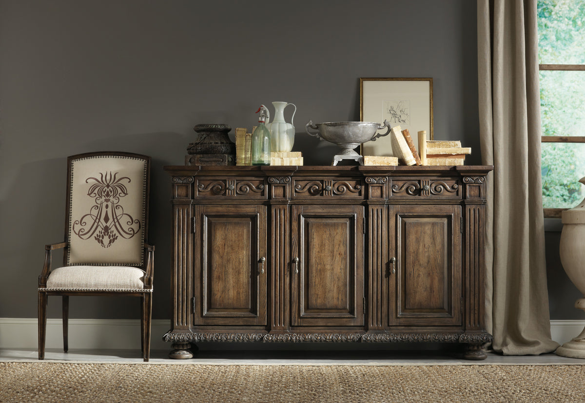 a wooden cabinet with a bowl on top and a chair in front of it