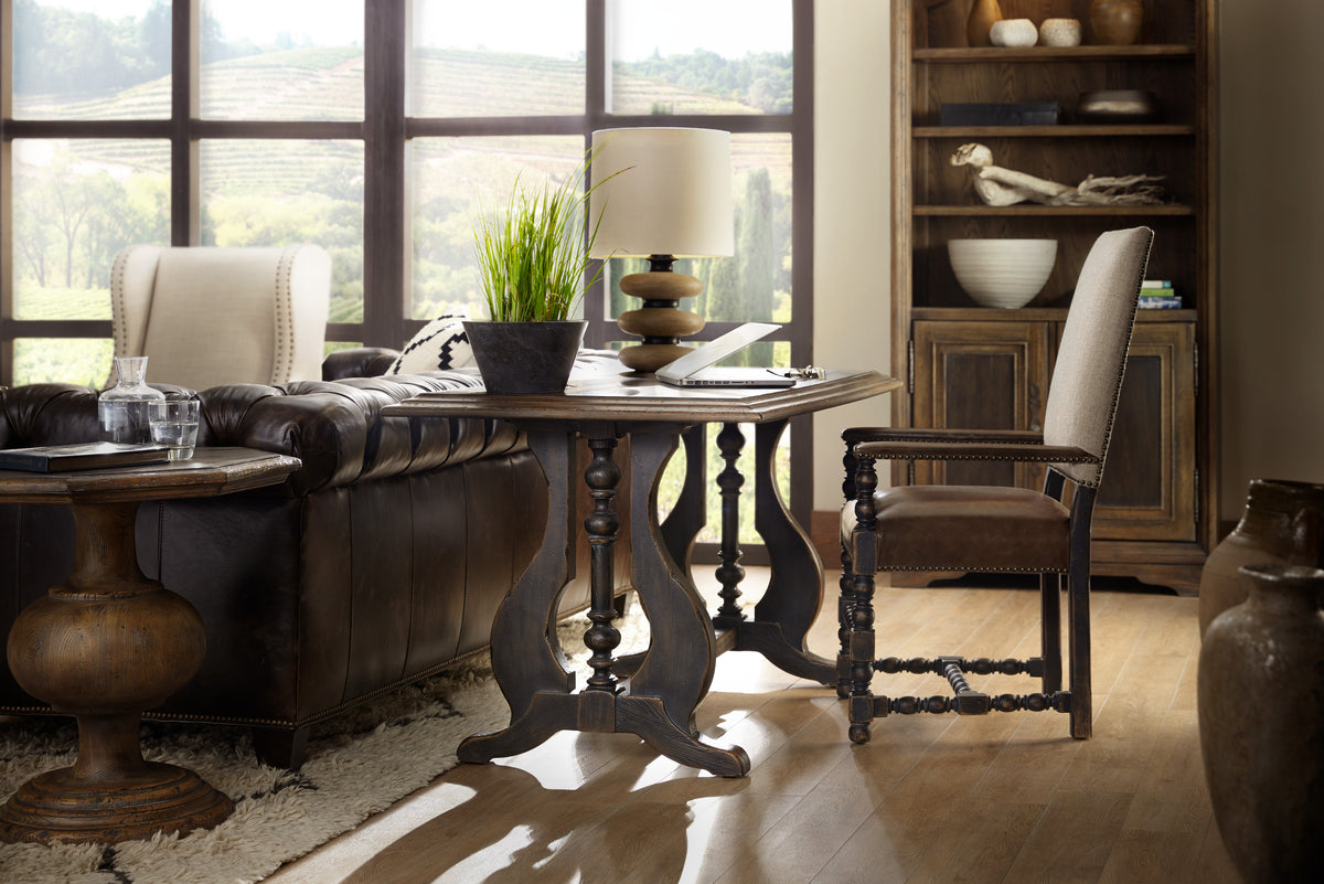 a table with a lamp and a plant in a room with a couch