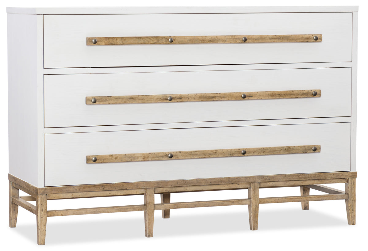 a white dresser with wooden handles