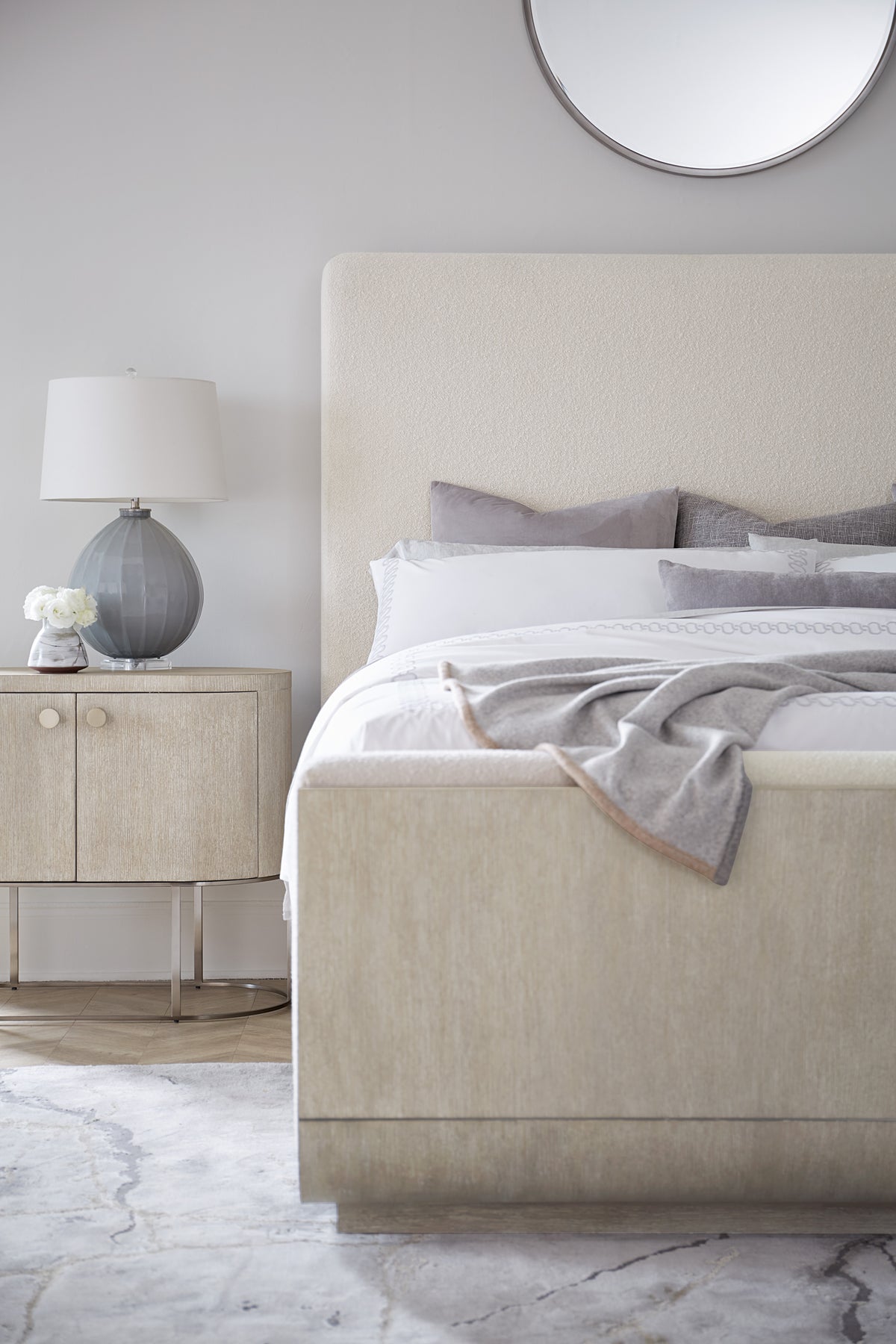 a bed with a white headboard and a lamp